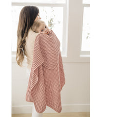 Konssy waffle baby blanket blush pink draped over crib, versatile wrap for newborns and toddlers.