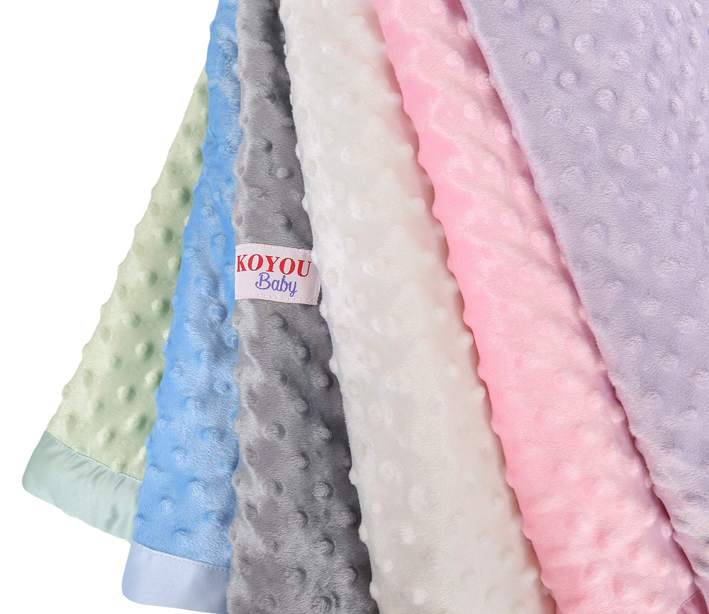 KOYOU Baby Pink blanket on a crib adds a luxurious decorative touch.