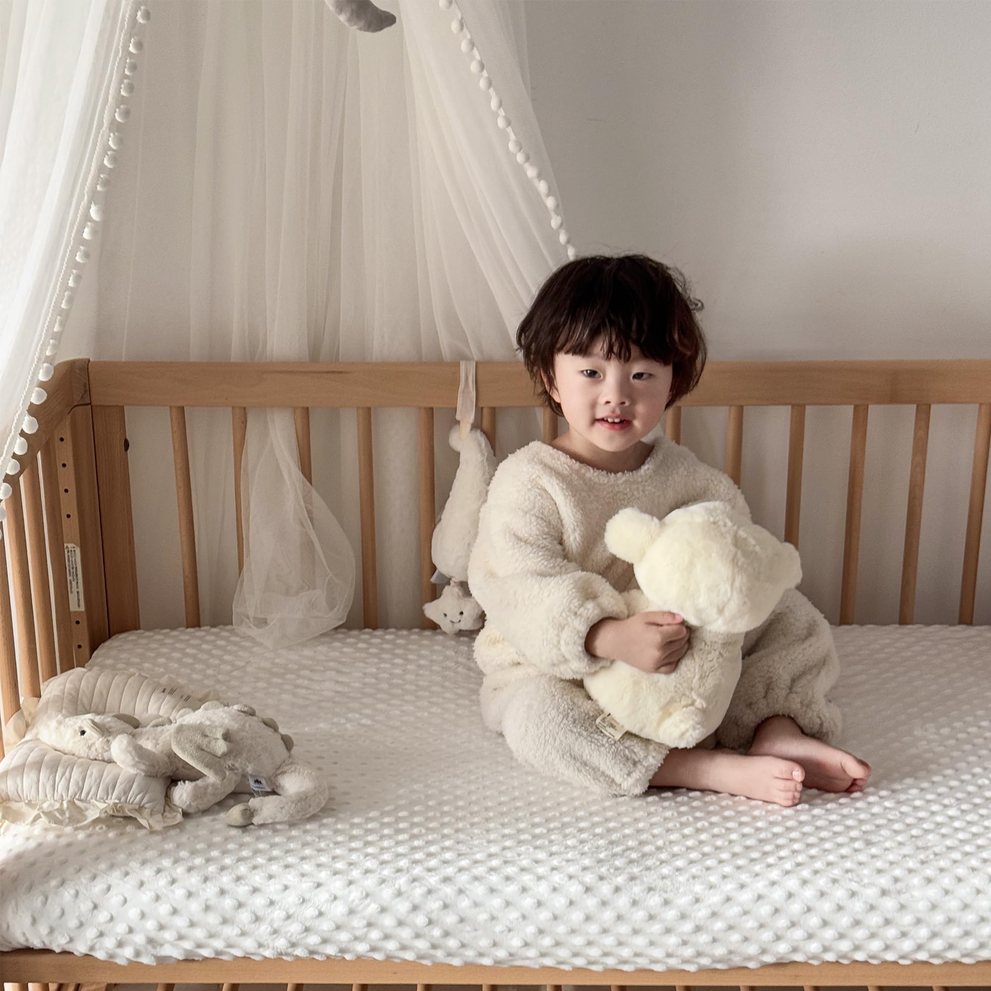 La Sheer fuzzy crib sheets — elastic banding visible for secure, slip-free fit.