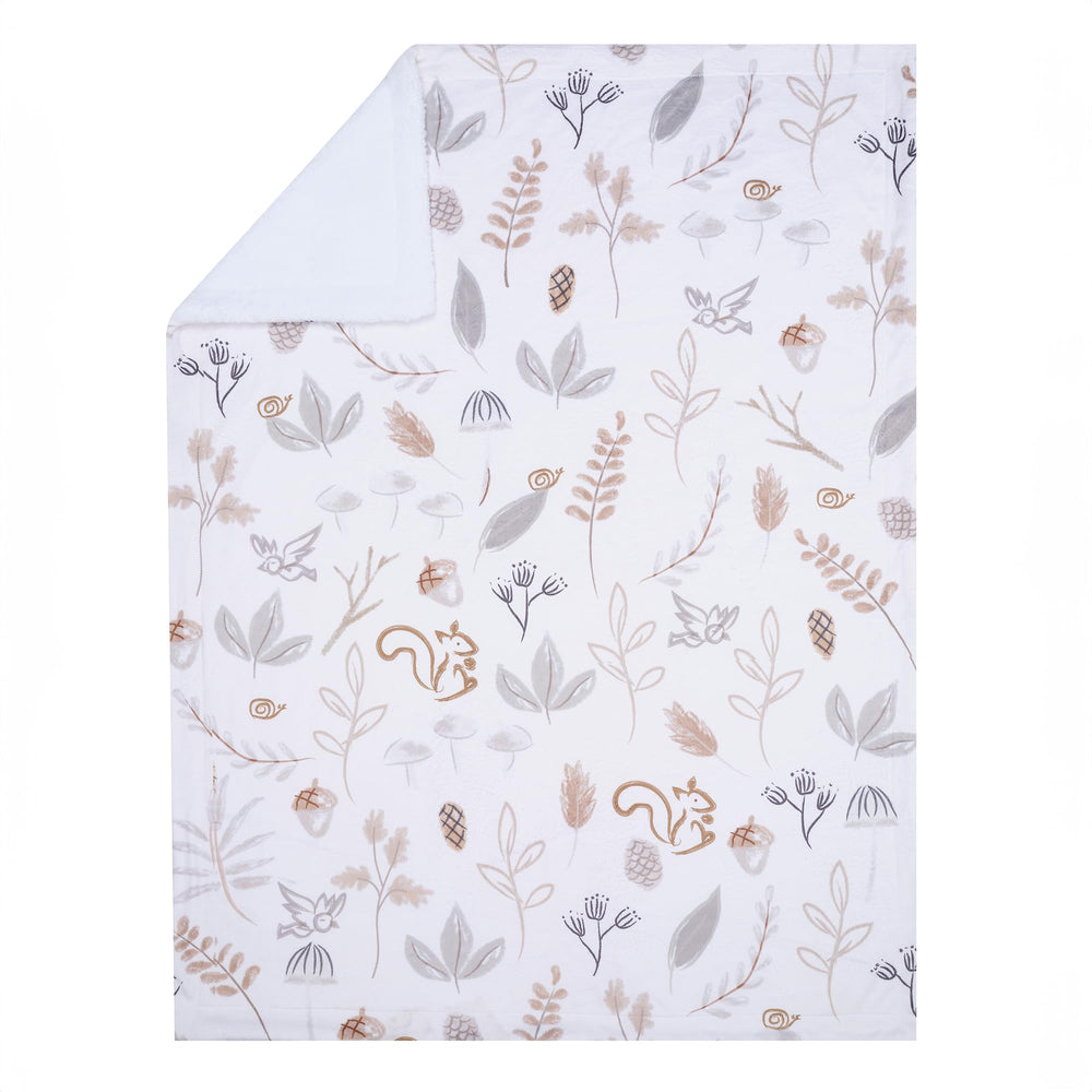 Lambs & Ivy nursery decor idea with forest blanket adds woodland charm.