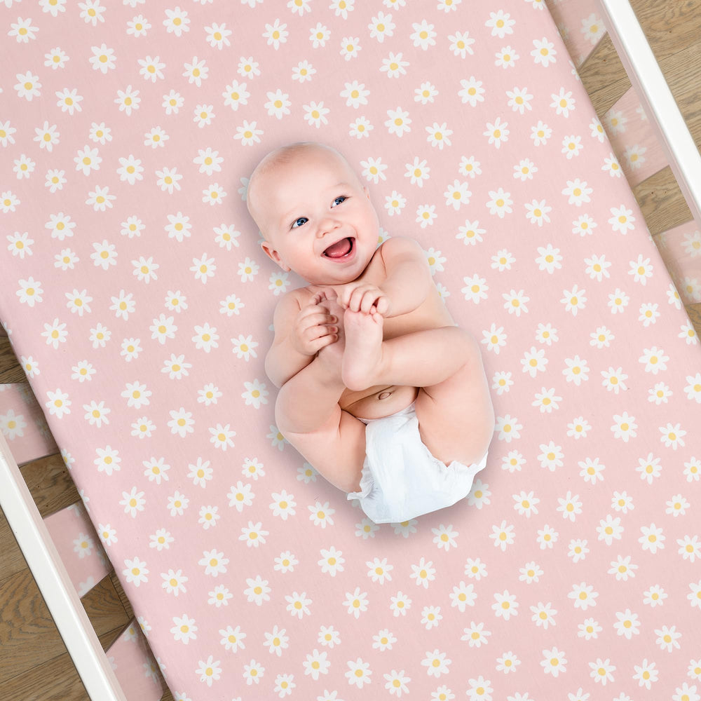 Lambs & Ivy Daisy Dreams rose-daisy print sheet enhances nursery decor and warmth.