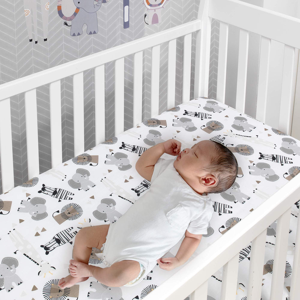 Lambs & Ivy Jungle Safari animal-printed fitted sheet for breathable crib comfort.