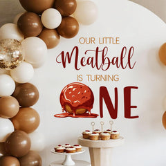 LANKBACK Our Little Meatball Turning One decal provides a festive backdrop for photos.