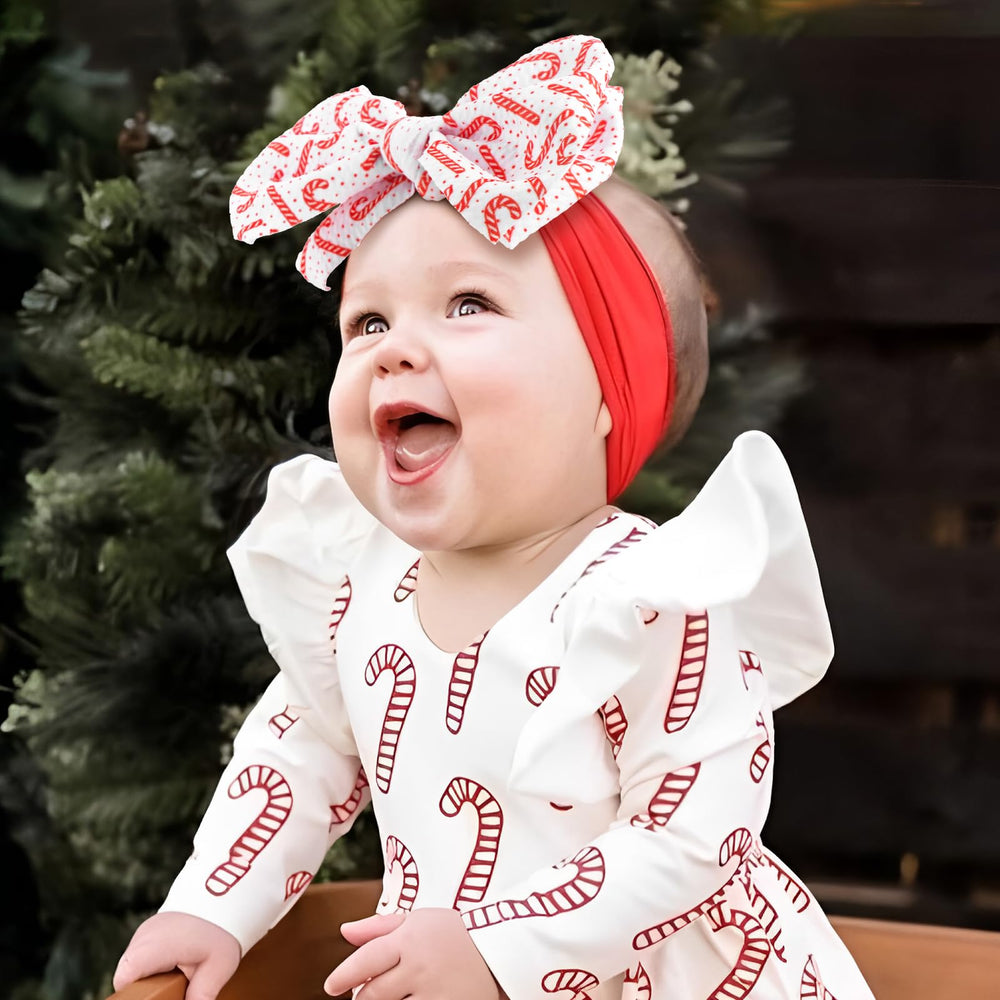 Lanmerry Candy Cane Bow Headband in red adds charm to baby looks.