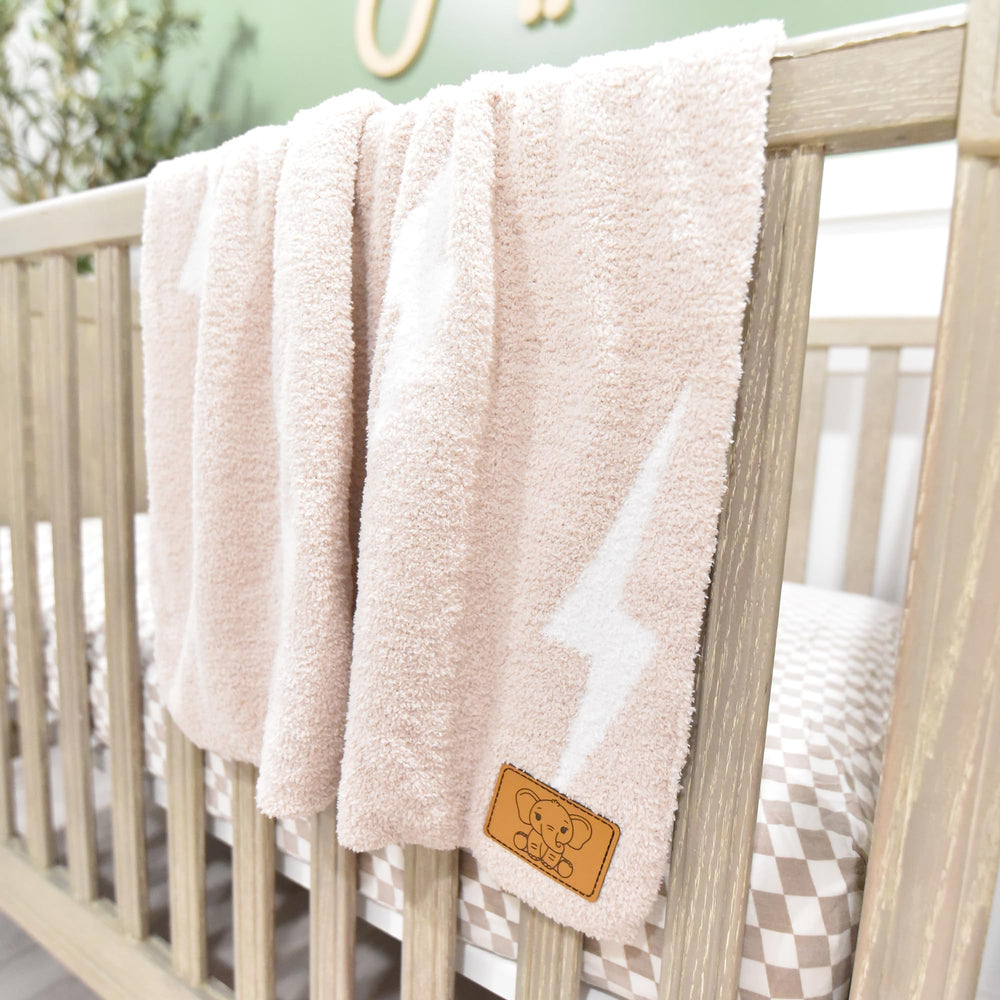 Tan/White Leaps + Legends Lightning Bolt blanket with gender-neutral appeal.
