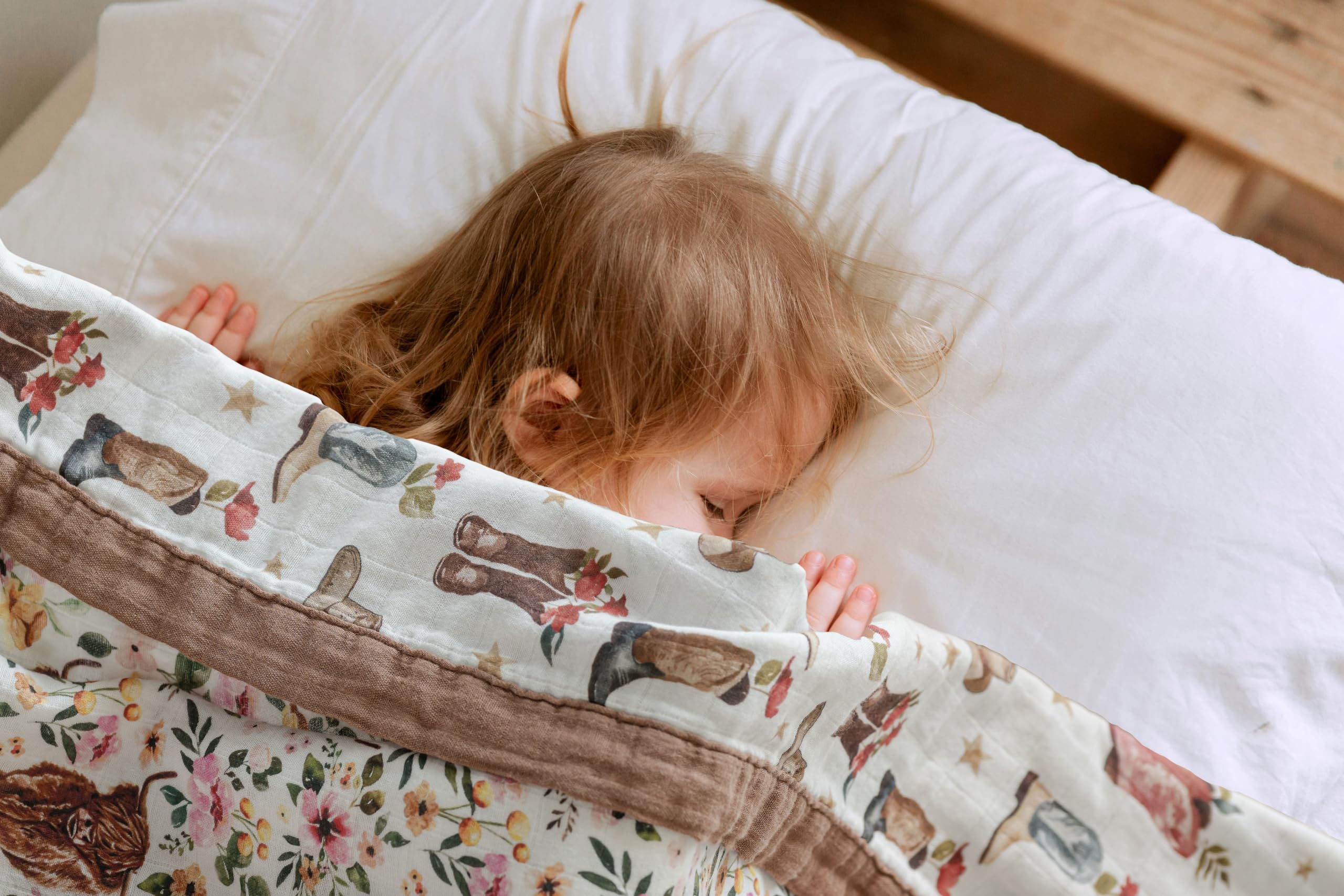 Little Jump cowgirl floral Highlandcow muslin blanket folded for nursery display.