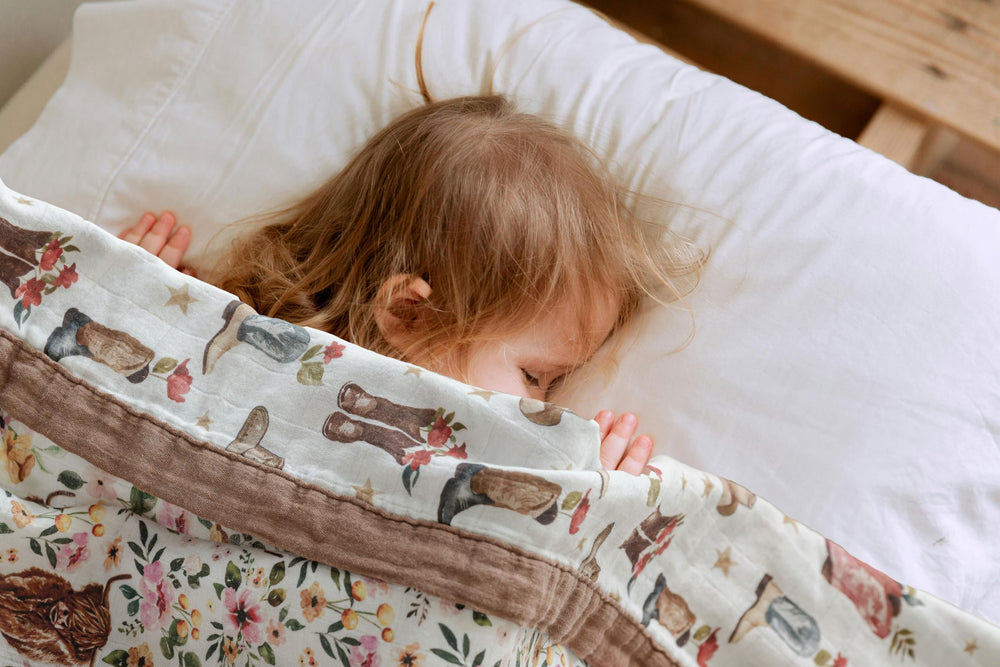 Little Jump cowgirl floral Highlandcow muslin blanket folded for nursery display.