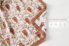 Little Jump cowgirl floral Highlandcow muslin blanket on baby during cuddling.