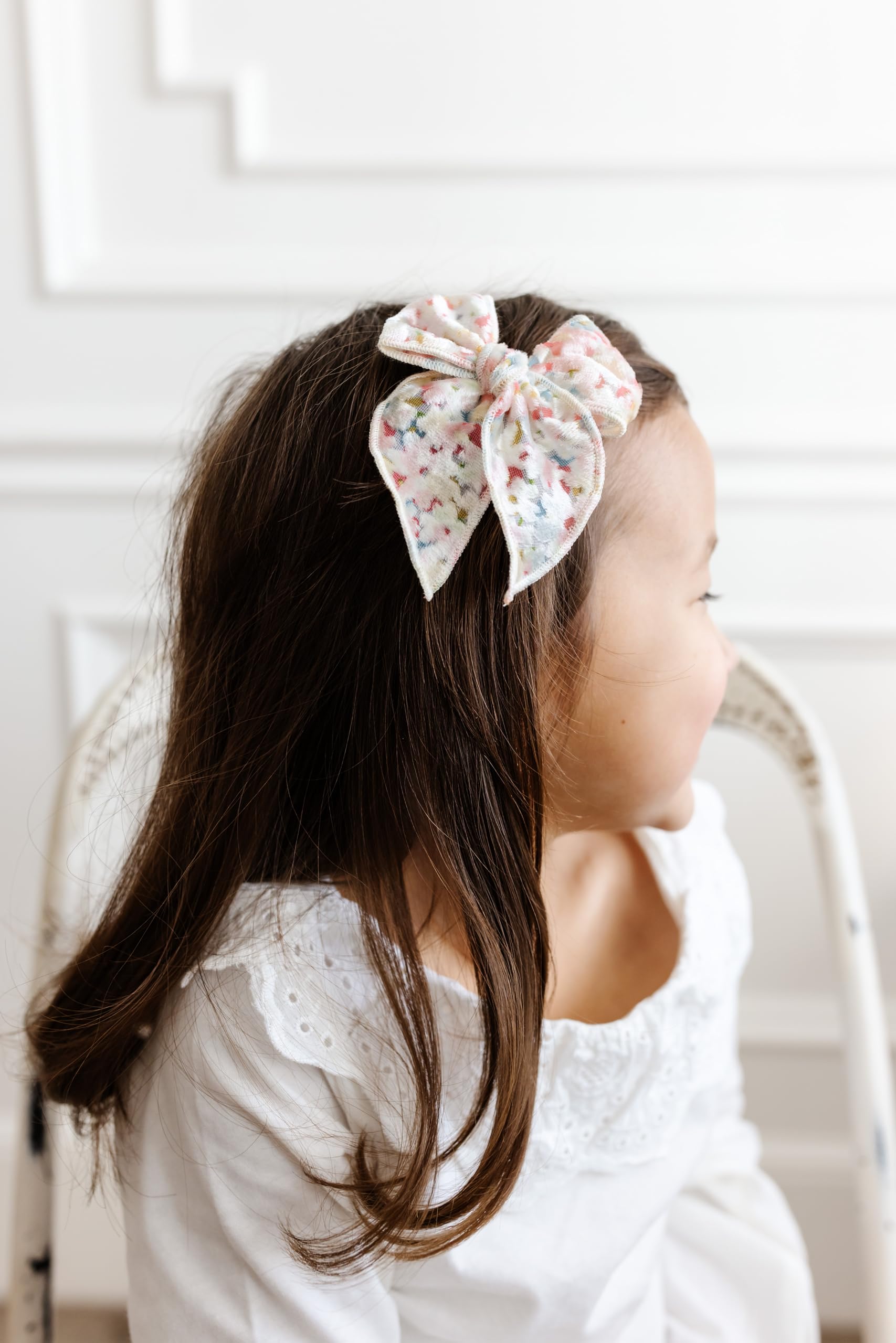 Baby wearing Little Poppy Co bows ready for daily outfits.