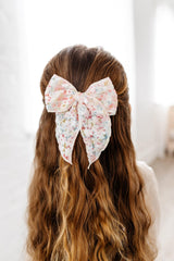 Soft nylon headband with Little Poppy Co mini bow for newborns.