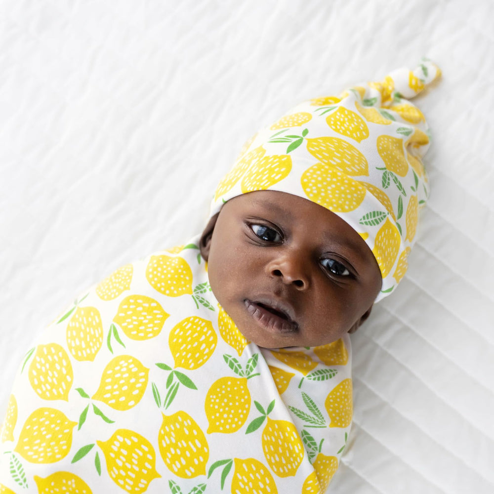 Little Sleepies Lemons swaddle used as stroller shade for sunny outings.