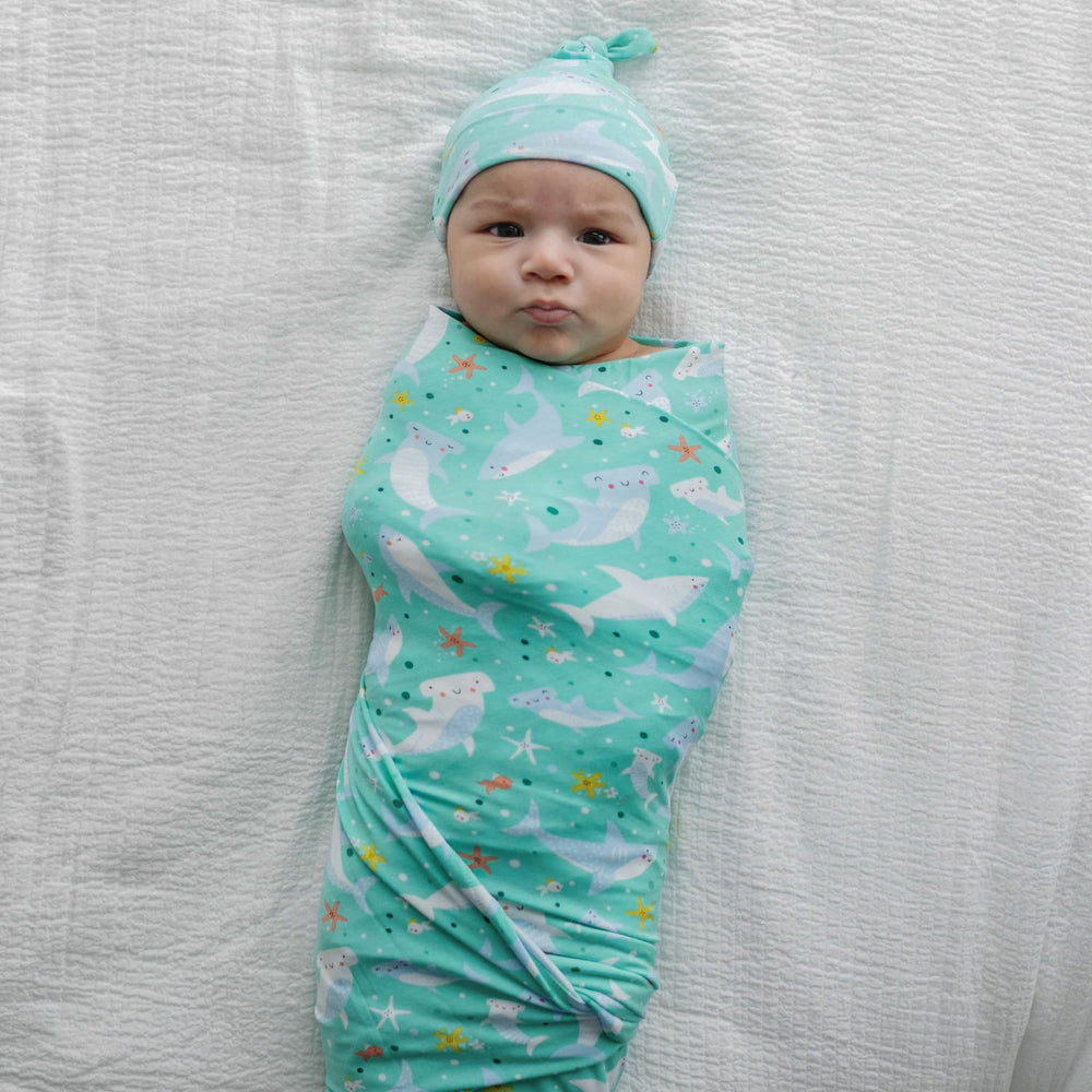 Little Sleepies Shark Soiree swaddle doubles as stroller shade.