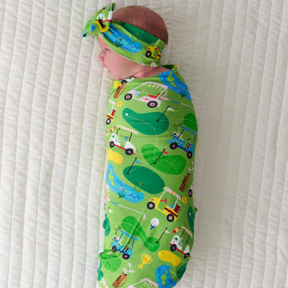 Little Sleepies swaddle doubling as stroller shade for sunny walks.