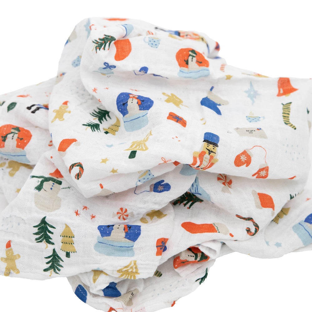 Little Unicorn Christmas Time swaddle wrapped around a car seat for travel.
