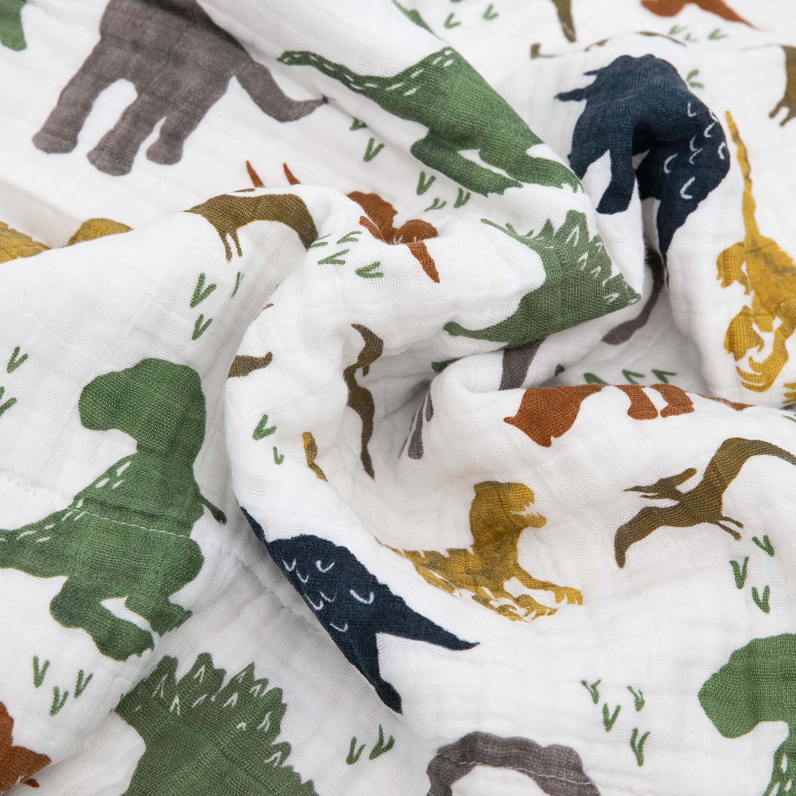 Folded Little Unicorn Dino Friends quilt demonstrates travel-friendly size.