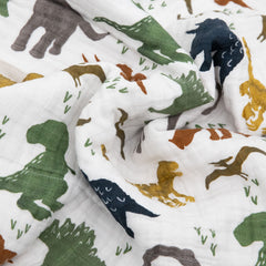 Folded Little Unicorn Dino Friends quilt demonstrates travel-friendly size.
