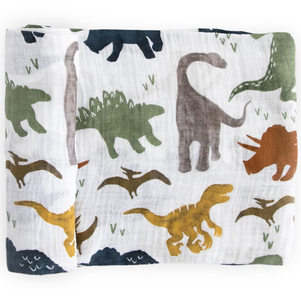 Little Unicorn dino friends swaddle blanket closeup shows soft breathable fabric for gentle swaddling.