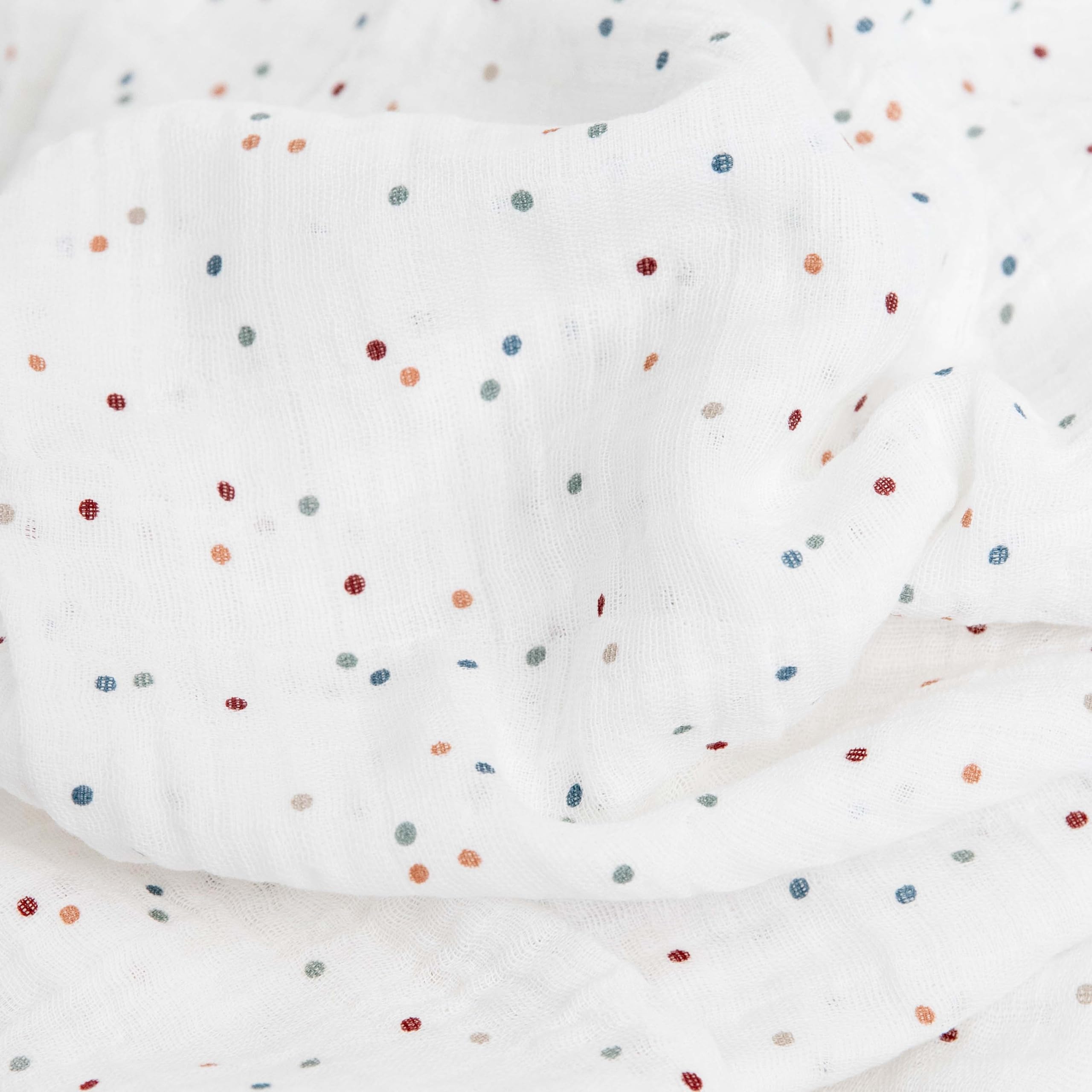 Little Unicorn dots swaddle wrapped baby demonstrating secure cozy swaddling