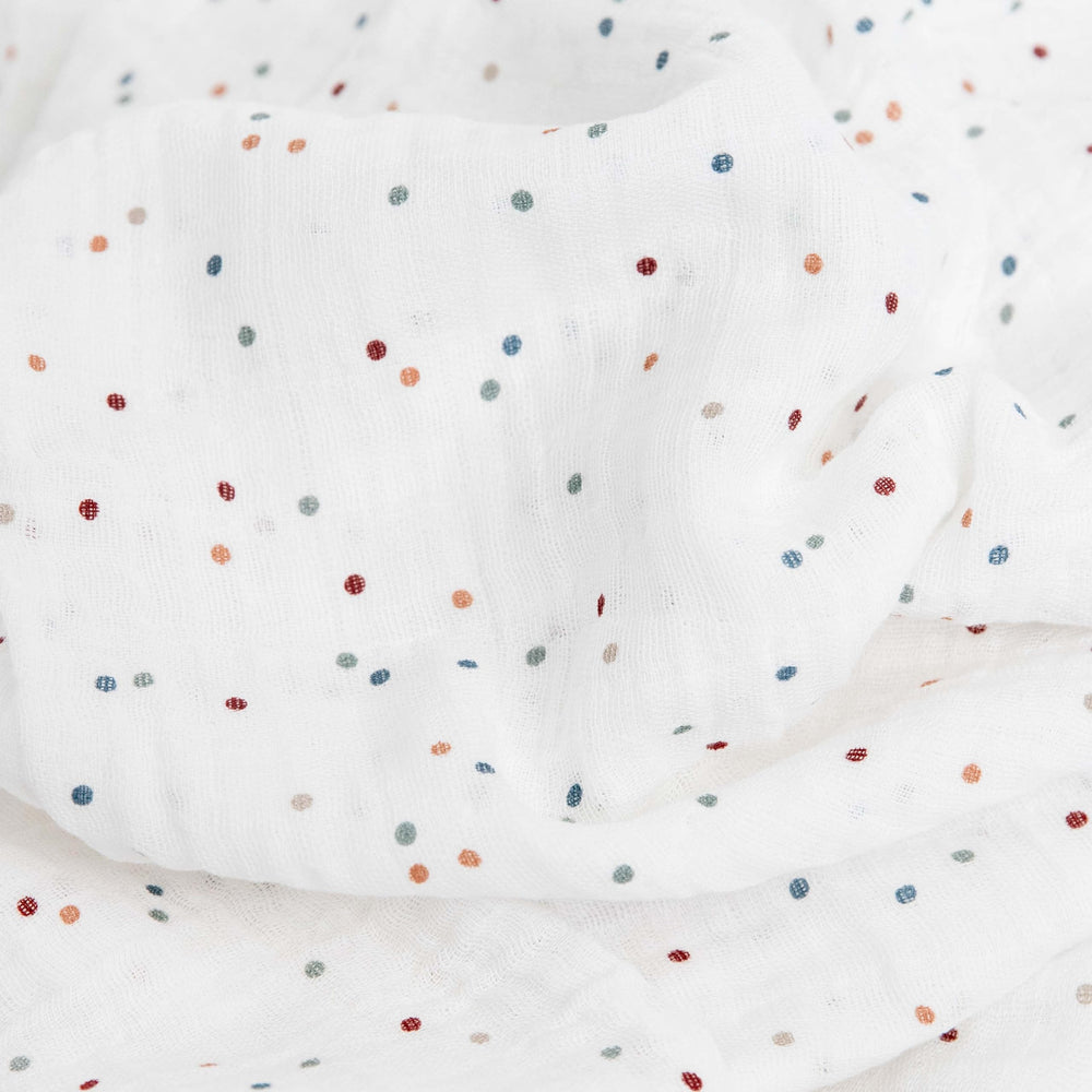 Little Unicorn dots swaddle wrapped baby demonstrating secure cozy swaddling