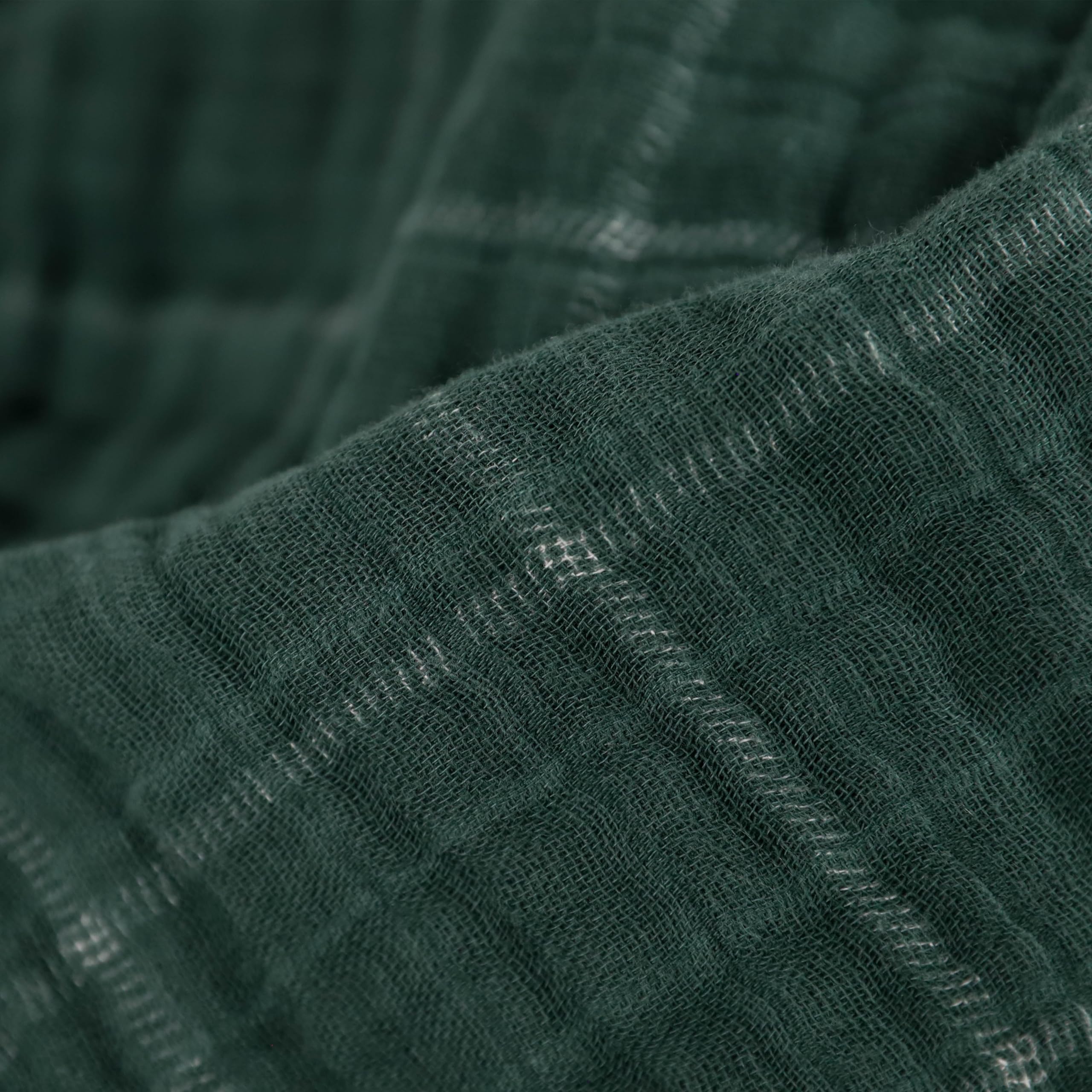 Little Unicorn Evergreen plaid muslin quilt on a stroller for on-the-go comfort
