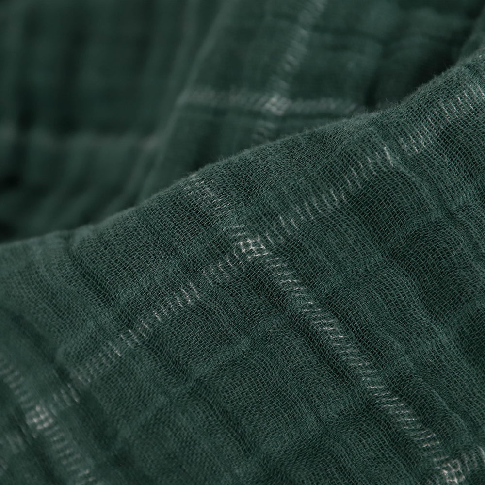 Little Unicorn Evergreen plaid muslin quilt on a stroller for on-the-go comfort