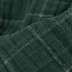 Little Unicorn Evergreen plaid muslin quilt on a stroller for on-the-go comfort