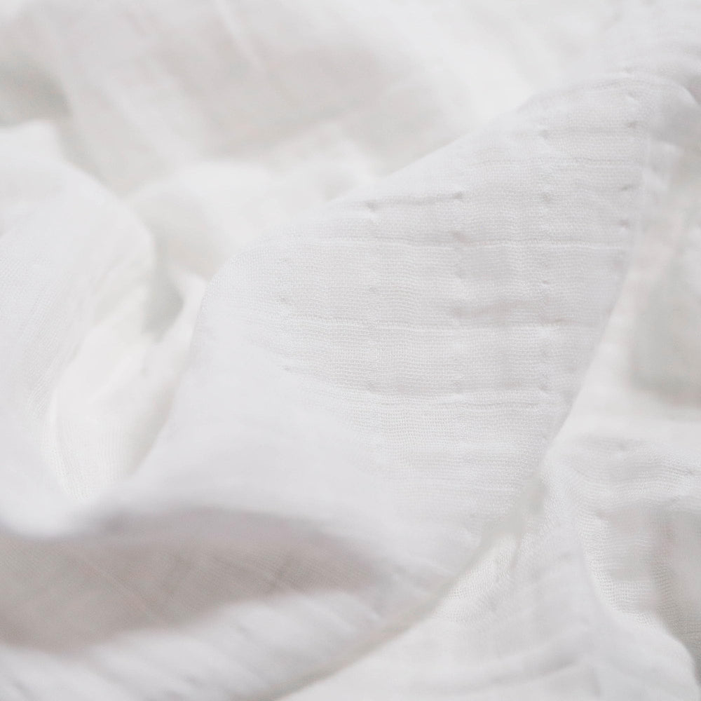 Little Unicorn muslin swaddle blanket white closeup shows gentle texture for baby skin.