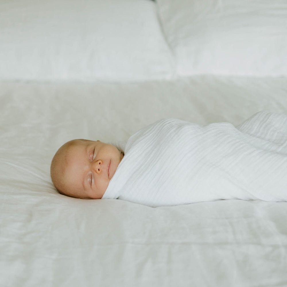 Little Unicorn muslin swaddle blanket white lightweight breathable fabric supports temperature balance.