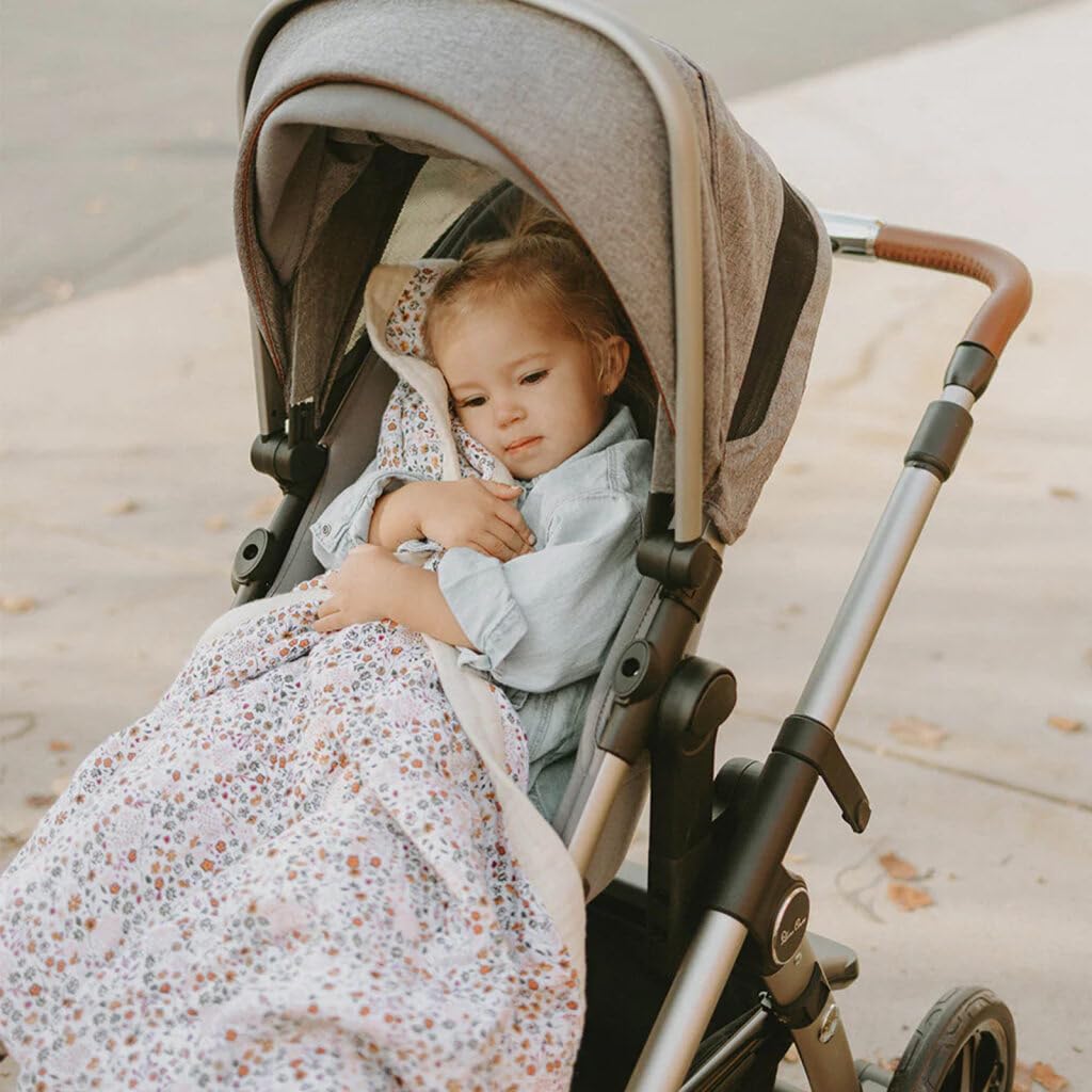 Little Unicorn newborn quilt in use as a cozy travel cover for naps.