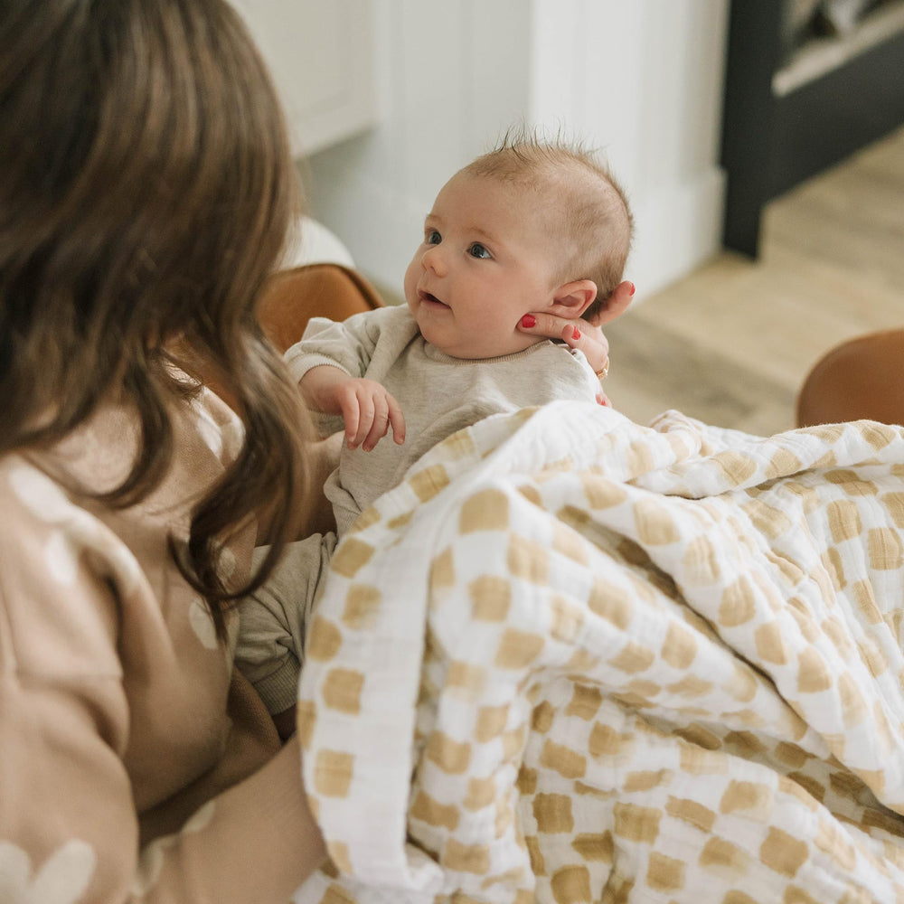 Little Unicorn newborn receiving quilt used as car-seat wrap for cozy travel.