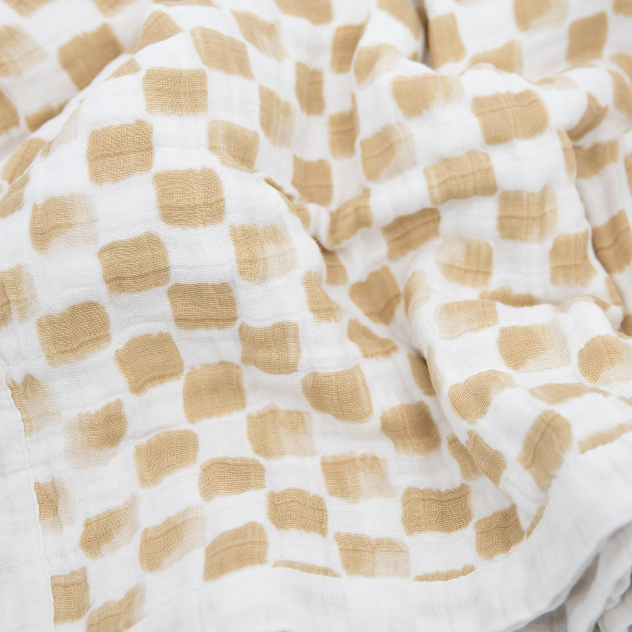 Little Unicorn newborn receiving quilt in hand shows generous size and drape.