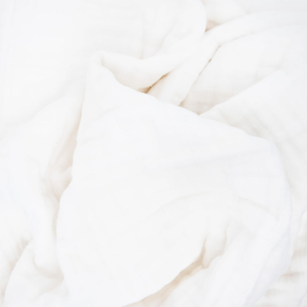 Little Unicorn organic quilt in nursery decor offering soft ambience.