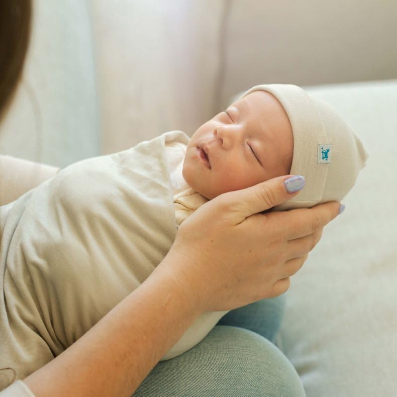 Little Unicorn Pebble hat top-knot adjusted for growing baby