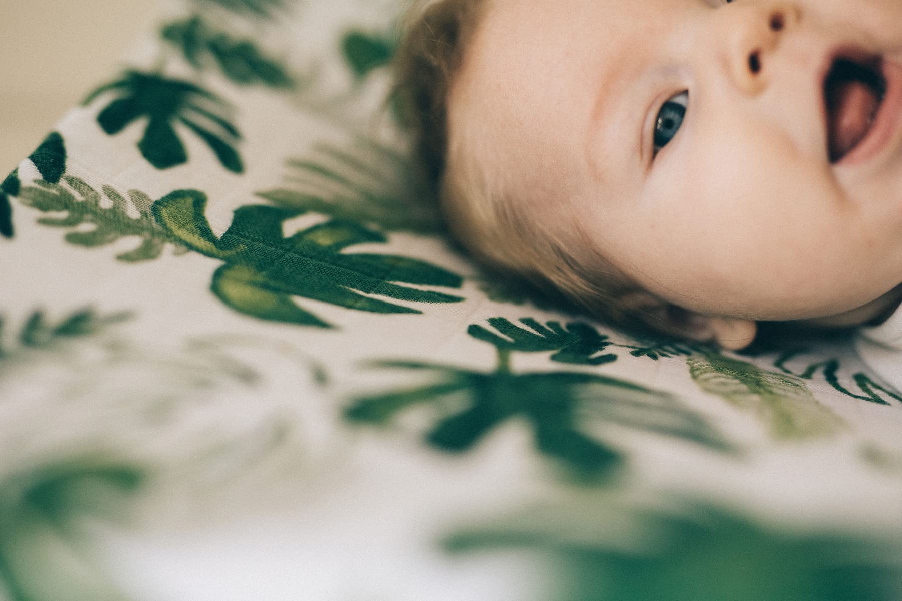 Little Unicorn premium changing pad cover tropical leaf image implies dryer-safe care and color retention
