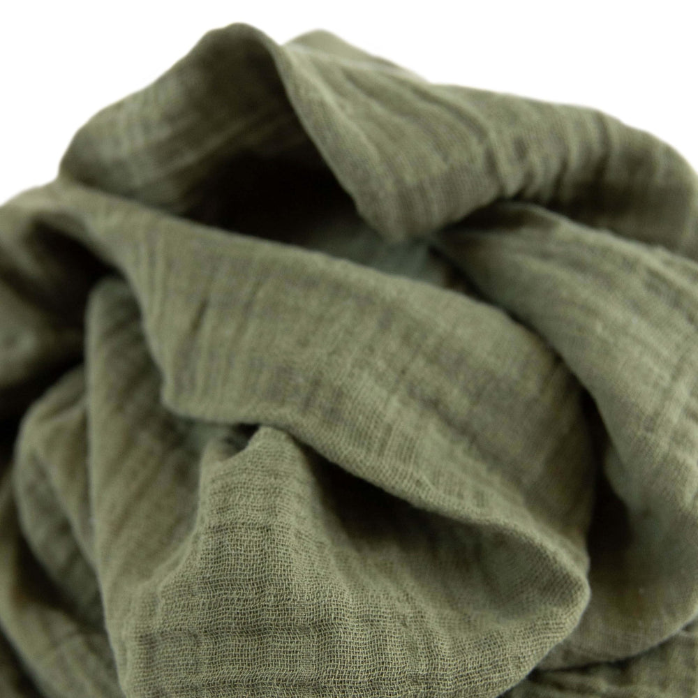 Little Unicorn Fern swaddle in a cozy nap setting, breathable comfort.
