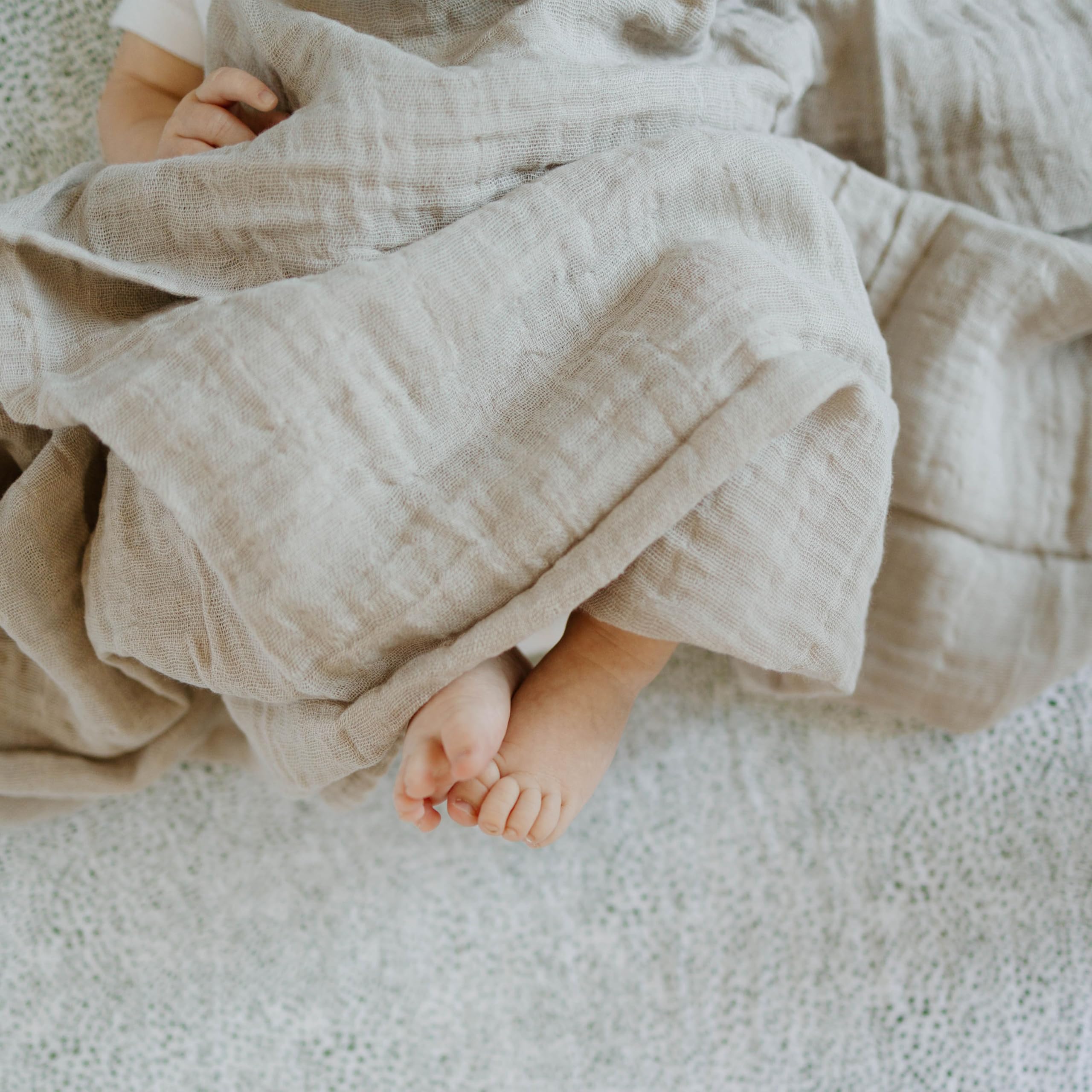 Baby play on a soft Little Unicorn swaddle blanket