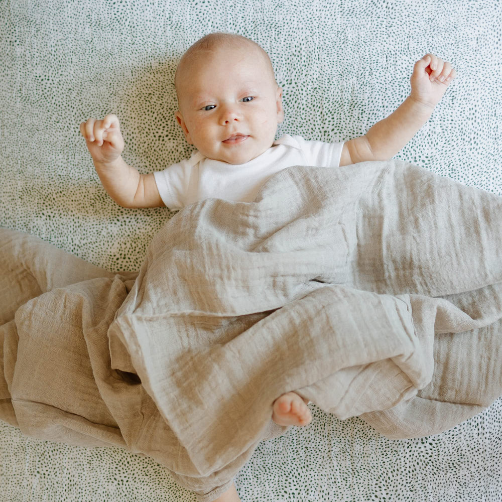 Nursing moment with Little Unicorn swaddle providing light coverage