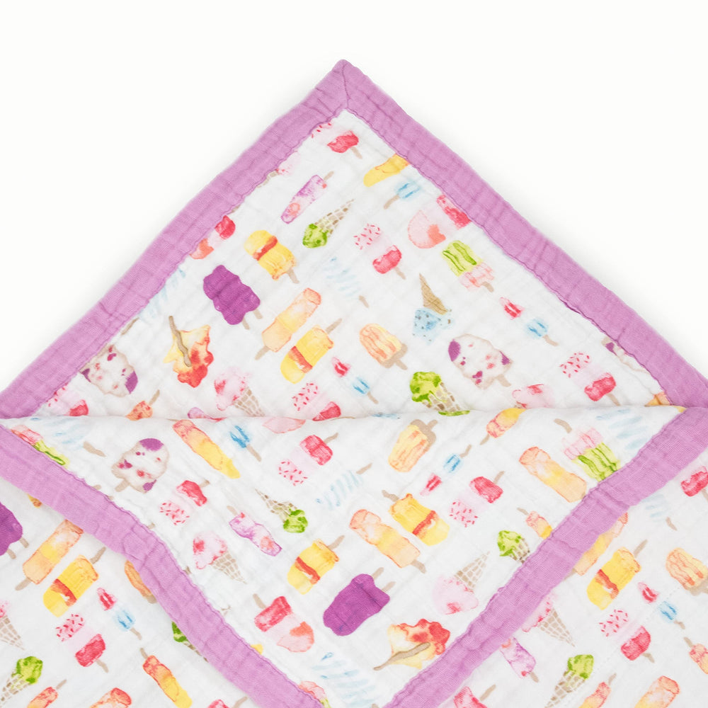 Little Unicorn Premium Quilted Throw folded for travel, lightweight warmth on the go
