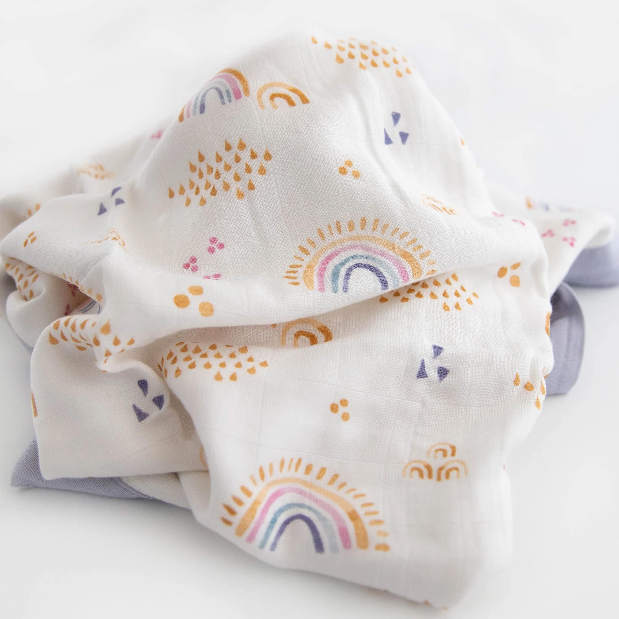 Little Unicorn Rainbows & Raindrops Deluxe Muslin Quilt in nursery decor setup showcases lightweight warmth