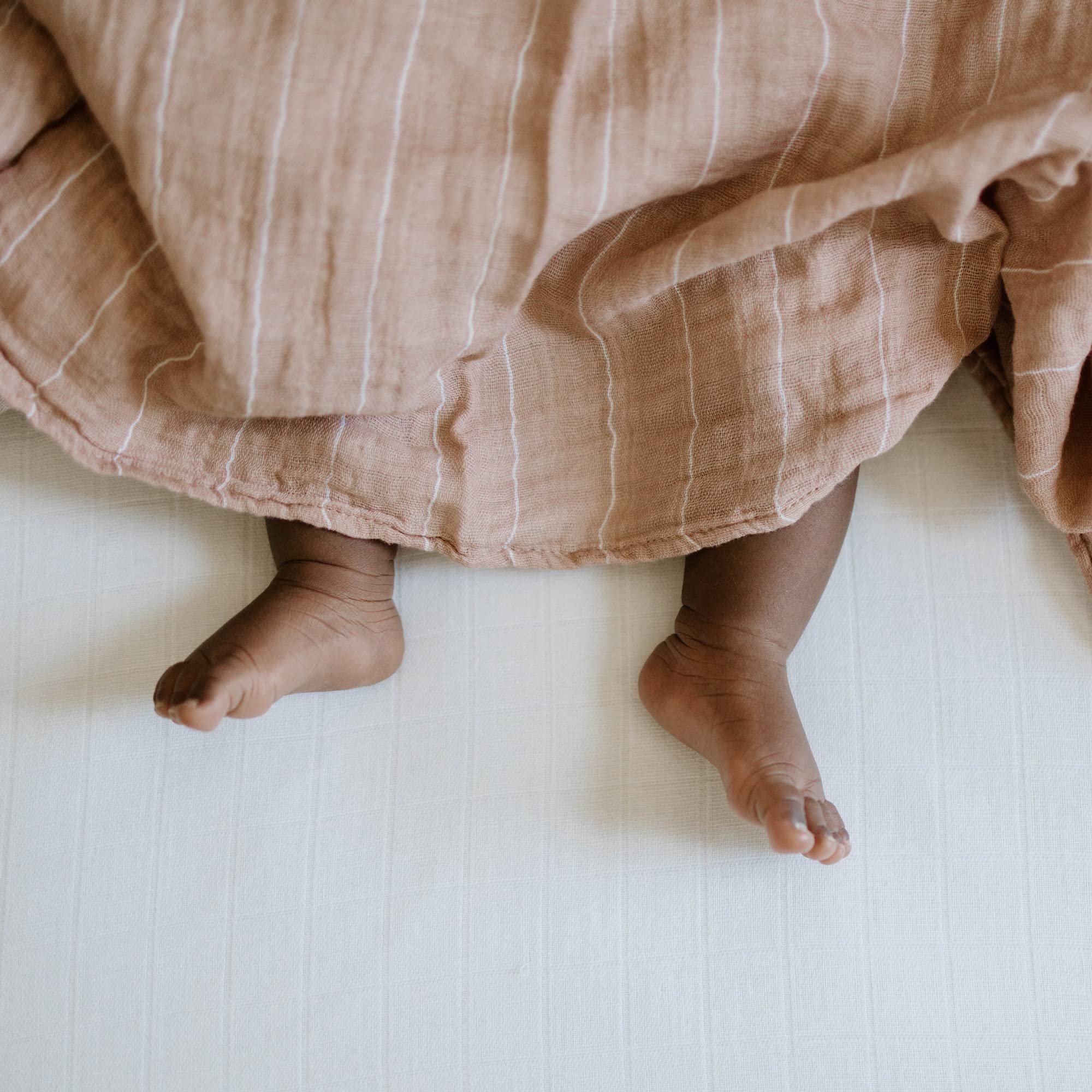 Little Unicorn Mauve Stripe swaddle in nursery decor for stylish touch.