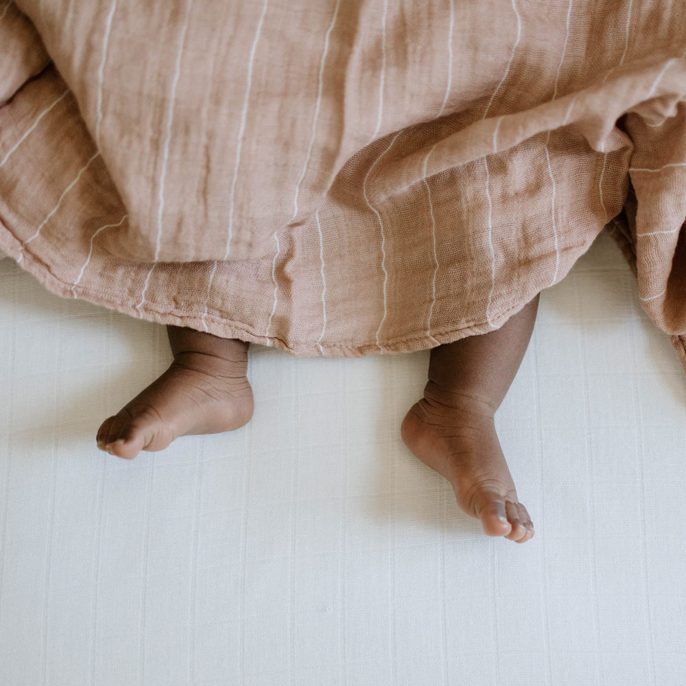 Little Unicorn Mauve Stripe swaddle in nursery decor for stylish touch.