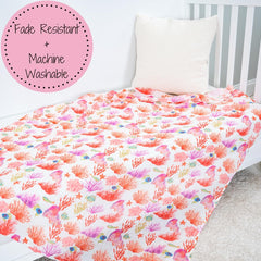 LollyBanks baby wrapping snugly with coral blanket in nursery