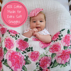 LollyBanks Peony Print swaddle in baby's arms, soft cotton muslin provides secure comfort.