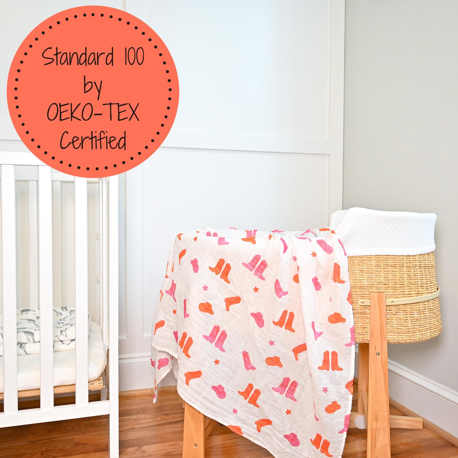 LollyBanks swaddle in a nursery setting, pink boot print accent on the crib decor.