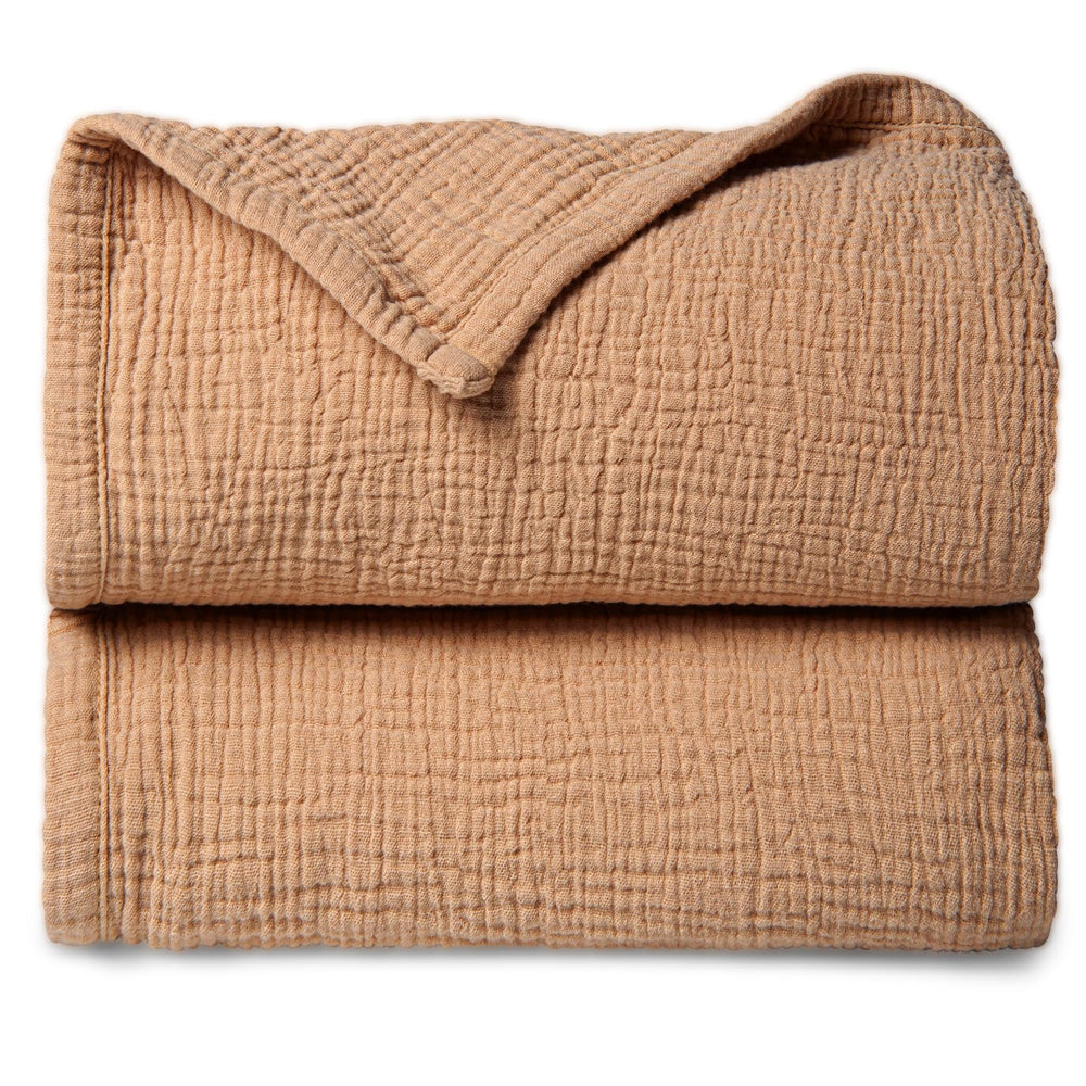 Lulu Moon muslin baby blanket in caramel spread for cozy warmth.