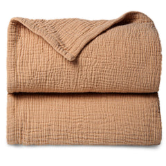 Lulu Moon muslin baby blanket in caramel spread for cozy warmth.