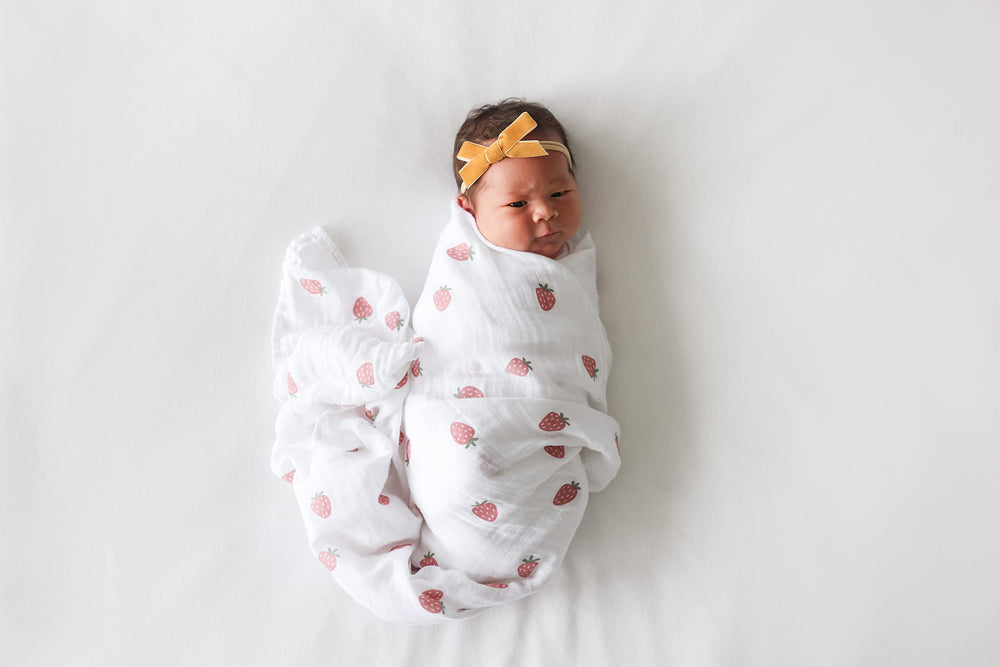 Lulujo swaddle blanket serving as a stroller shield for on-the-go.