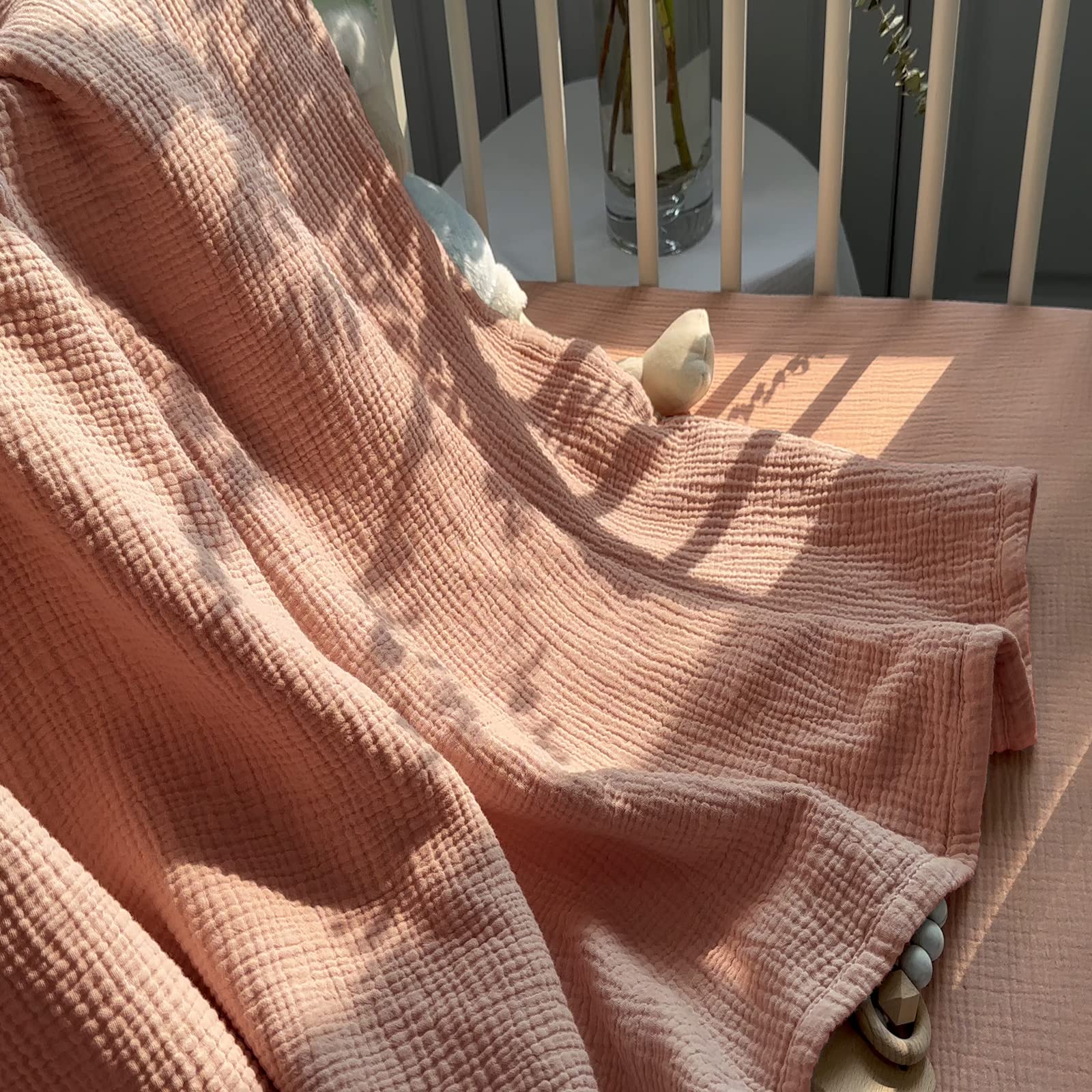 Lulumoon pink muslin blanket lifestyle shot ideal for beach or stroller outings.