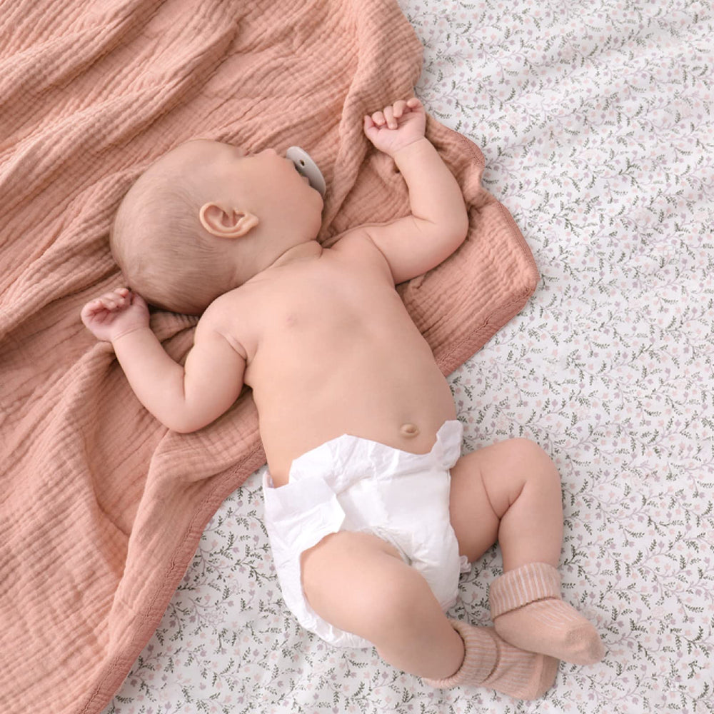 Lulumoon pink muslin blanket laid out for naptime with ample 47x47 inch size.