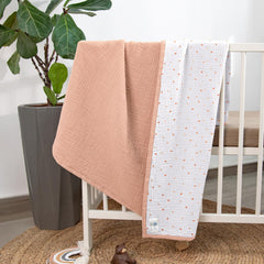 Lulumoon muslin blanket in nursery-use setup beside a crib.